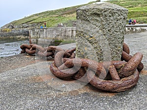 Huge rusted metal mooring chain in a harbour