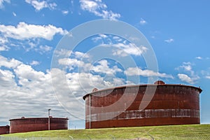 Huge rusty storage tanks full of petroleum products in tank farm in Cushing Oklahoma where most oil in USA is stored and traded