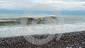 Huge sea waves of dirty water crashes powerfully on the shore in storm in slow motion