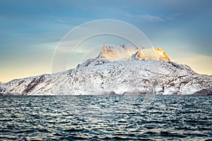Huge Sermitsiaq mountain covered in snow with sea in the foreground, nearby Nuuk city, Greenland