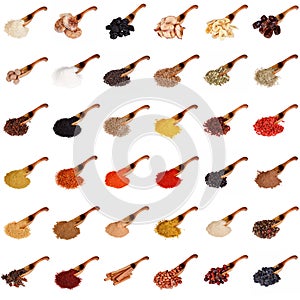 Huge set of spices, dried fruits, nuts, herbs and beans on the wooden spoon isolated on white.