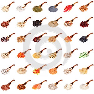 Huge set of spices, dried fruits, nuts, herbs and beans on the wooden spoon isolated on white background.