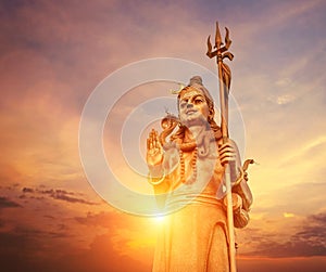 The huge Shiva statue Mangal Mahadev is a 33 m art piece in Ganga talao temple on the blue evening sunset sky, Mauritius island