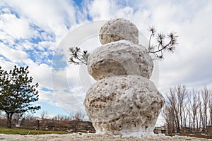 Huge spring snowman in melted meadow. Background with copy space for lettering or text