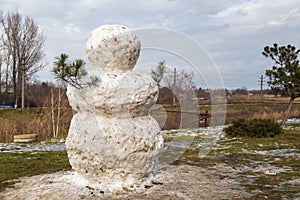 Huge spring snowman in melted meadow. Background with copy space for lettering or text