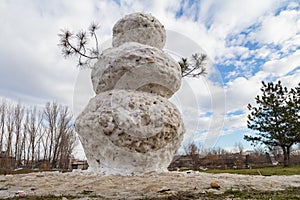 Huge spring snowman in melted meadow. Background with copy space for lettering or text