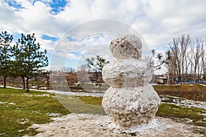 Huge spring snowman in melted meadow. Background with copy space for lettering or text