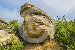 A huge stone against the sky and trees photo