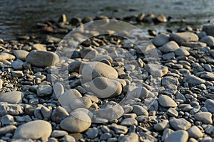 Huge stones on the river bank. River stones and clean, clear water of the river. Pebble stones on the shore are close in