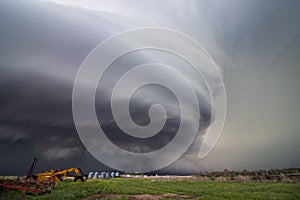 A huge supercell storm with a ground scraping wall cloud fills the sky over Nebraska farmland. photo