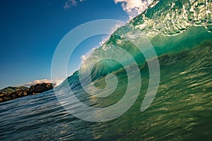 Huge surfing waves in ocean water in sunset light