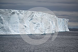 Huge table iceberg with texture in dark rough Southern Ocean, Antarctica