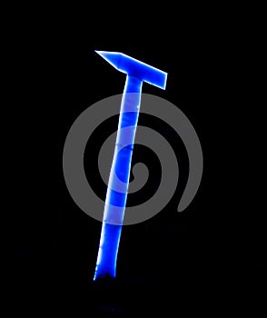 Huge and tall blue neon hammer in the dark night