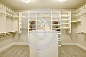 Huge walk-in closet with shelves, drawers and shoe racks.