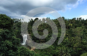 Huge waterfall in tropical forest. Bright exotic nature with fresh water stream.