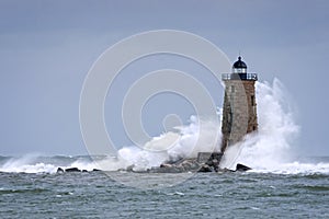 Huge Waves Crashing Around Stone Lighthouse Tower in Maine