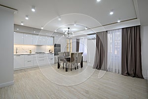 Huge white luxury kitchen in a studio apartment interior