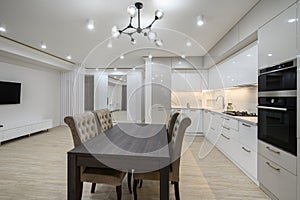 Huge white luxury kitchen in a studio apartment interior