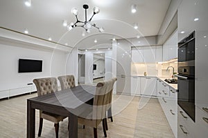 Huge white luxury kitchen in a studio apartment interior