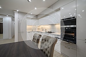 Huge white luxury kitchen in a studio apartment interior