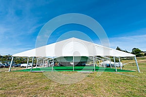 Huge white tent with green floor in field photo