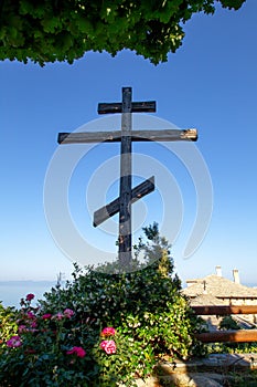Huge wooden Orthodox eight-pointed cross against the sky after the dawn on Mount Athos