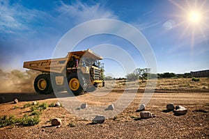 huge yellow mining truck on a dirt road