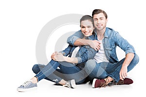 hugging couple sitting in denim clothes,