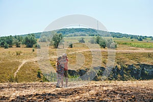 Hugging couple on sunny hill