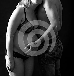 Hugging pair, pregnant woman and her partner