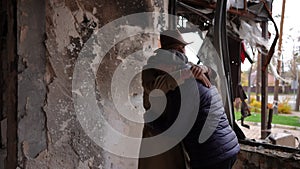 Hugging senior sad couple standing in destroyed war torn building thinking. Portrait of depressed desperate hopeless man