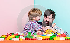 Hugs Are Fully Returnable. building home with color constructor. small boy with dad playing together. child development