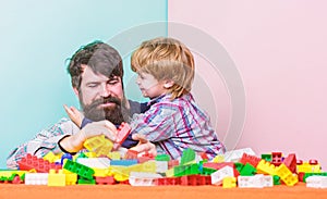 Hugs Are Fully Returnable. building home with color constructor. small boy with dad playing together. child development