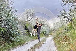 Hugs and kiss loving couple in the branches of the bushes. Walk along the road, a man kissing a woman. Love affection relationship