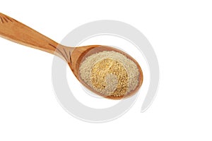 Hulbah powder or Fenugreek flour in wooden spoon isolated on white background, close-up, selective focus. Herbal nutritional