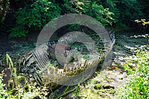 hull of destroyed wooden boat. An old rotten wooden boat in a shallow riverbed