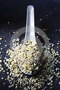 Hulled hemp seeds on a dark gray surface