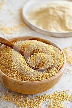 Hulled millet grain and flour in bowls