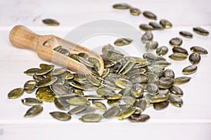 Hulled pumpkin seeds on grey wood