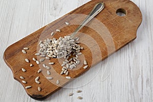 Hulled sunflower seeds on rustic wooden board, low angle view. Close-up photo