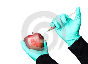 Human being injected chemicals into red apple, pesticides and fertilizers and chemicals with a syringe