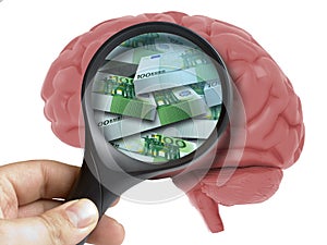 Human Brain Analyzed with magnifying glass pack of euro banknotes inside isolated