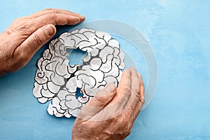 Human brain made of paper on a blue background a thrifty hand protects the human brain. photo