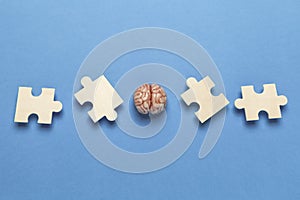 Human brain with a puzzle on blue background. Business idea, memory loss, training and new skills