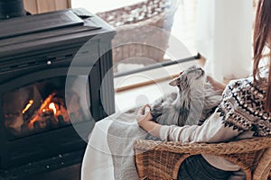 Human with cat relaxing by the fire place