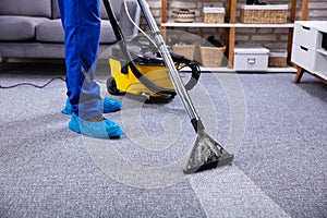 Person Cleaning Carpet With Vacuum Cleaner photo