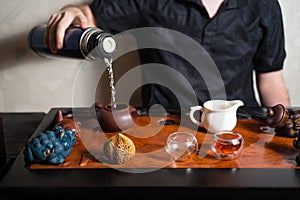 Human in dark clothes sitting behind tea table