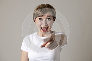 Human expressions and emotions. Young attractive woman laughing and pointing at the camera.