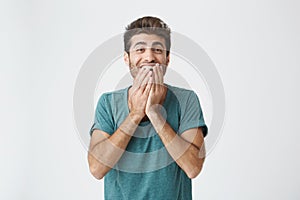 Human face expressions, emotions and feelings. Astonished and surprised bearded young man in blue t-shirt pointing at