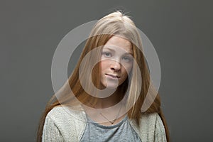 Human face expressions and emotions. Portrait of young adorable redhead woman with pouting lips in cozy shirt looking confused.